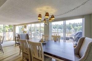 A dining area with a large table, chairs, and a chandelier. - Pine Point: 3BR, 2BA, Private Dock & Kayaks! (Holland)