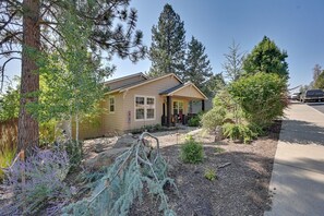 A single-story house with a front porch, surrounded by a variety of trees and shrubs. - Remote Work Ready! Quiet Extended Stay in Bend (Bend)
