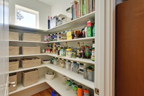 A well-organized pantry with multiple shelves, containing various food items, kitchenware, and storage containers. - Remote Work Ready! Quiet Extended Stay in Bend (Bend)