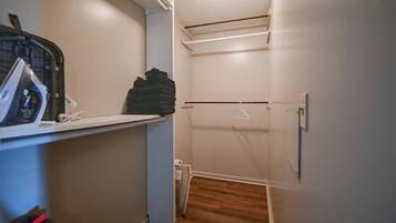 A laundry room with a washing machine, a dryer, and a stack of folded clothes.