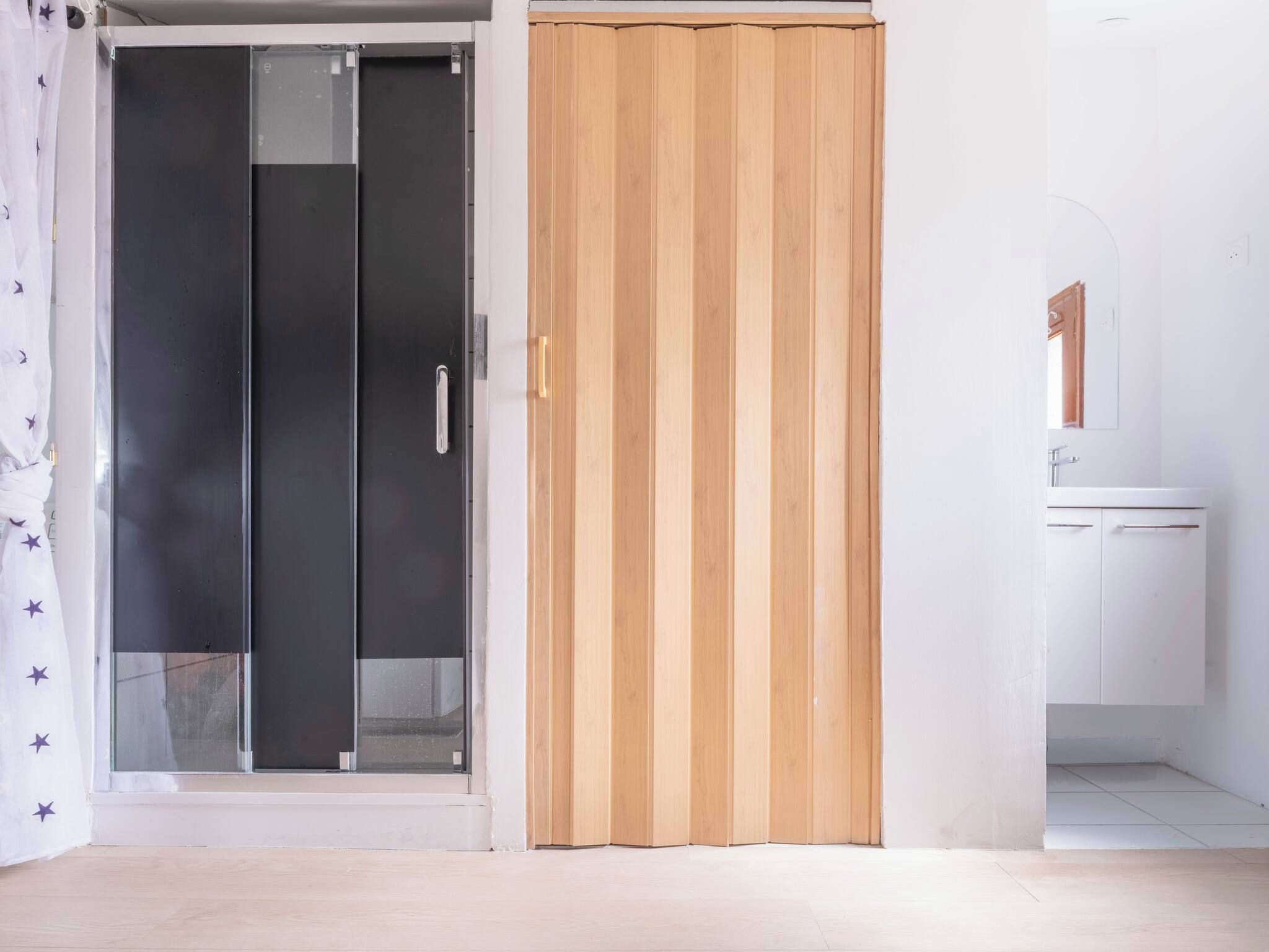 A room with a sliding door, a white cabinet, and a tiled floor.