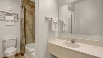 Une salle de bain comprenant des toilettes, un lavabo et un espace douche.