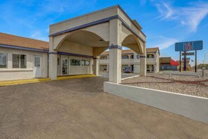 Un motel con un'area di parcheggio coperta e un cartello che indica il numero 6.