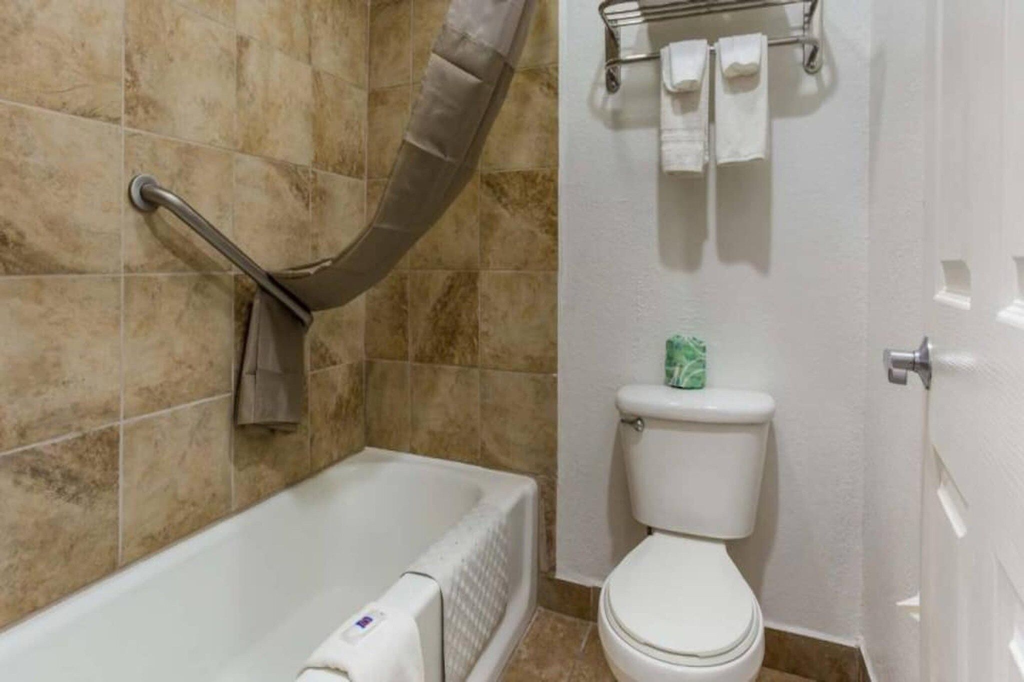 Kylpyhuone, jossa on kylpyamme, wc ja pyyheteline.