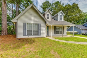 A two-story house with a covered porch, a front yard, and a large tree to the left. - Pet-Friendly Private Yard Near Charleston, Beaches (Goose Creek)