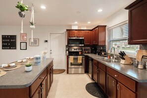 Une cuisine moderne avec des meubles en bois, des appareils électroménagers en acier inoxydable et une grande fenêtre.