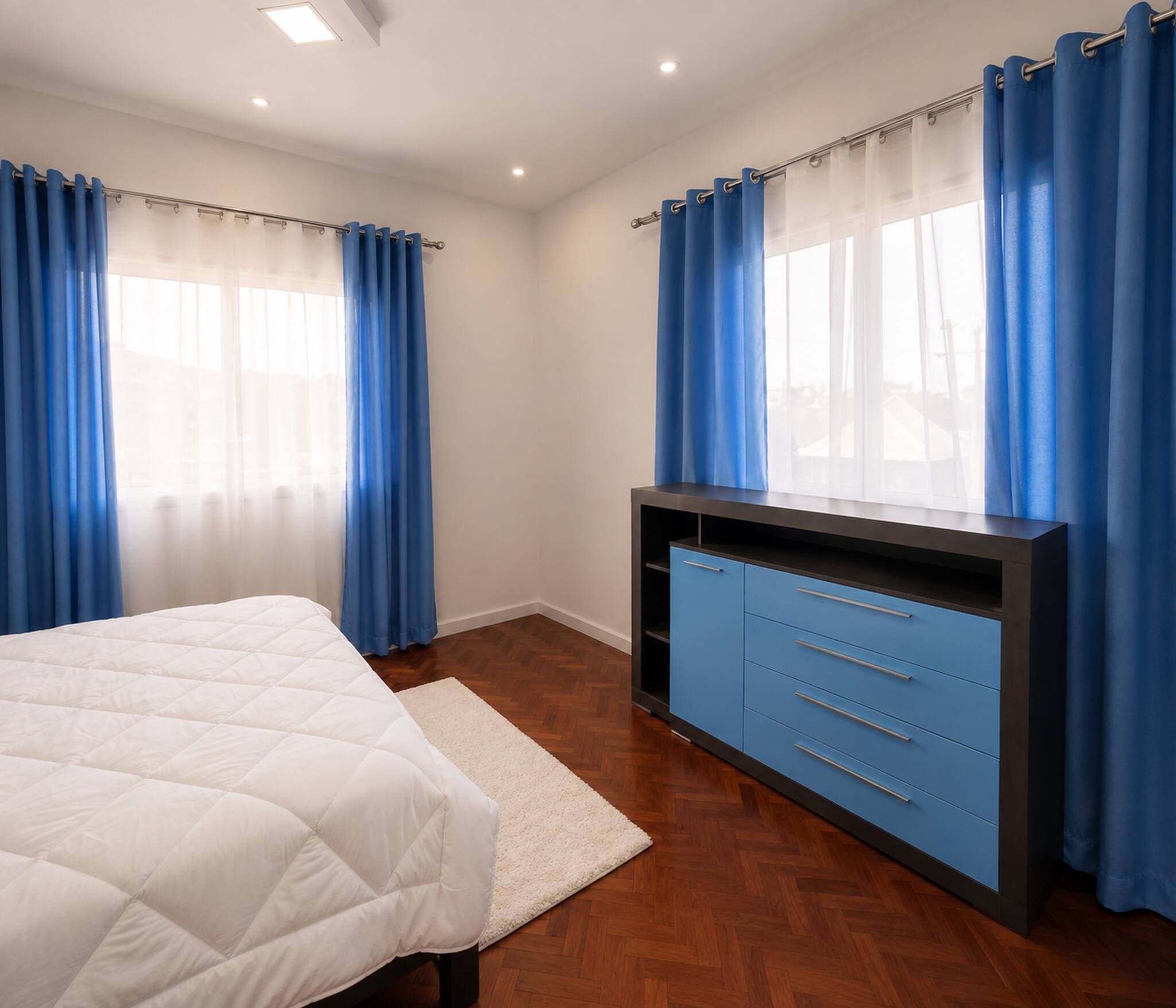 Un dormitorio con cama, cómoda y cortinas.