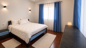 A modern bedroom with a bed, nightstands, a desk, and a window with curtains. - Modern Apartment • Free WiFi & Airport Transfer (Antananarivo)