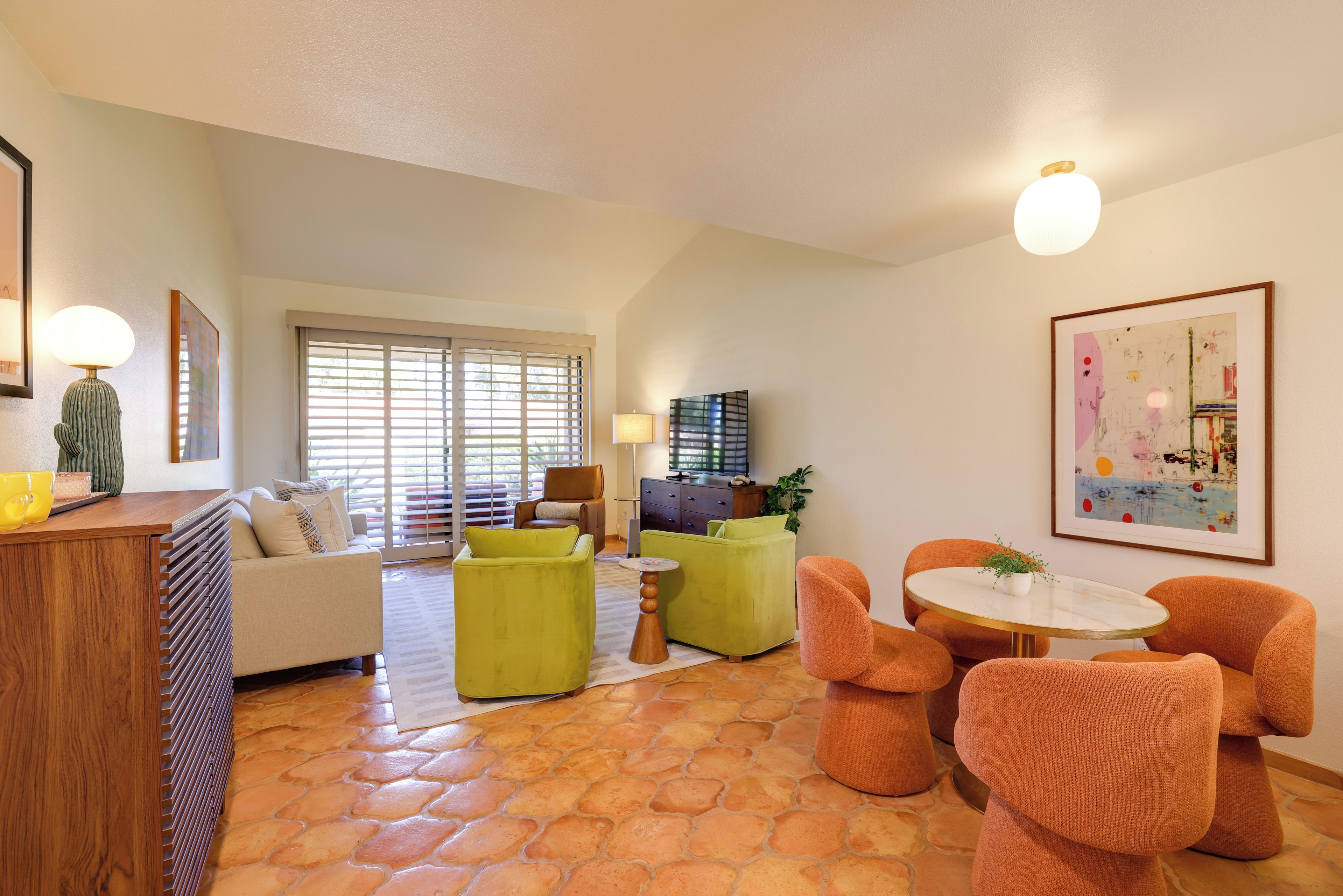 A living room with a sofa, two armchairs, a coffee table, and a TV.