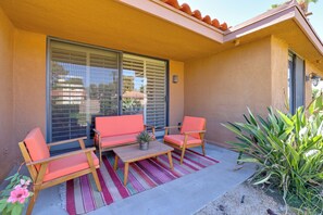 A balcony with two orange chairs, a small table, and a potted plant. - Sunrise Country Club Condo w/ Pool & Tennis (Rancho Mirage)