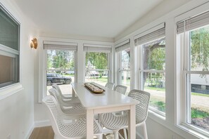 A sunroom with a table and chairs, large windows, and a view of the outside. - Sun, Surf & Seafood: York Home 2 Blocks to Beach (York)