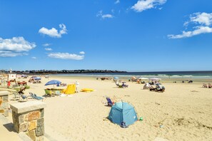 Una platja amb tendes de campanya, ombrelles i gandules.