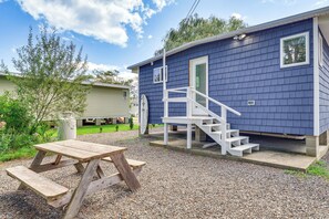 A blue building with a white staircase leading to a door, a picnic table, and a gravel ground. - Sun, Surf & Seafood: York Home 2 Blocks to Beach (York)