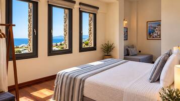 Ein Schlafzimmer mit einem großen Bett, Meerblick durch Fenster, einer Zimmerpflanze und einem Gemälde an der Wand.