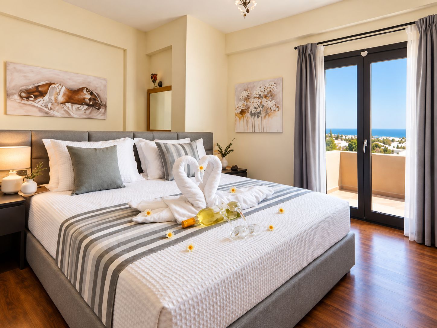 A hotel room with a large bed, a nightstand, a mirror, and artwork on the walls.