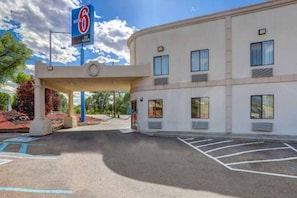 Ein Motel mit großem Parkplatz und einem Schild, das ein Einzelzimmer anzeigt.
