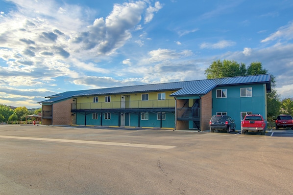 A multi-story building with a blue roof and a parking lot in front. - See the Royal Gorge! Cañon City Apartment (Cañon City)