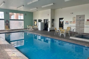 An indoor swimming pool with clear water, surrounded by lounge chairs and a tiled floor. - 2 Queen Beds | Smoking, Micfridge (Deming NM)