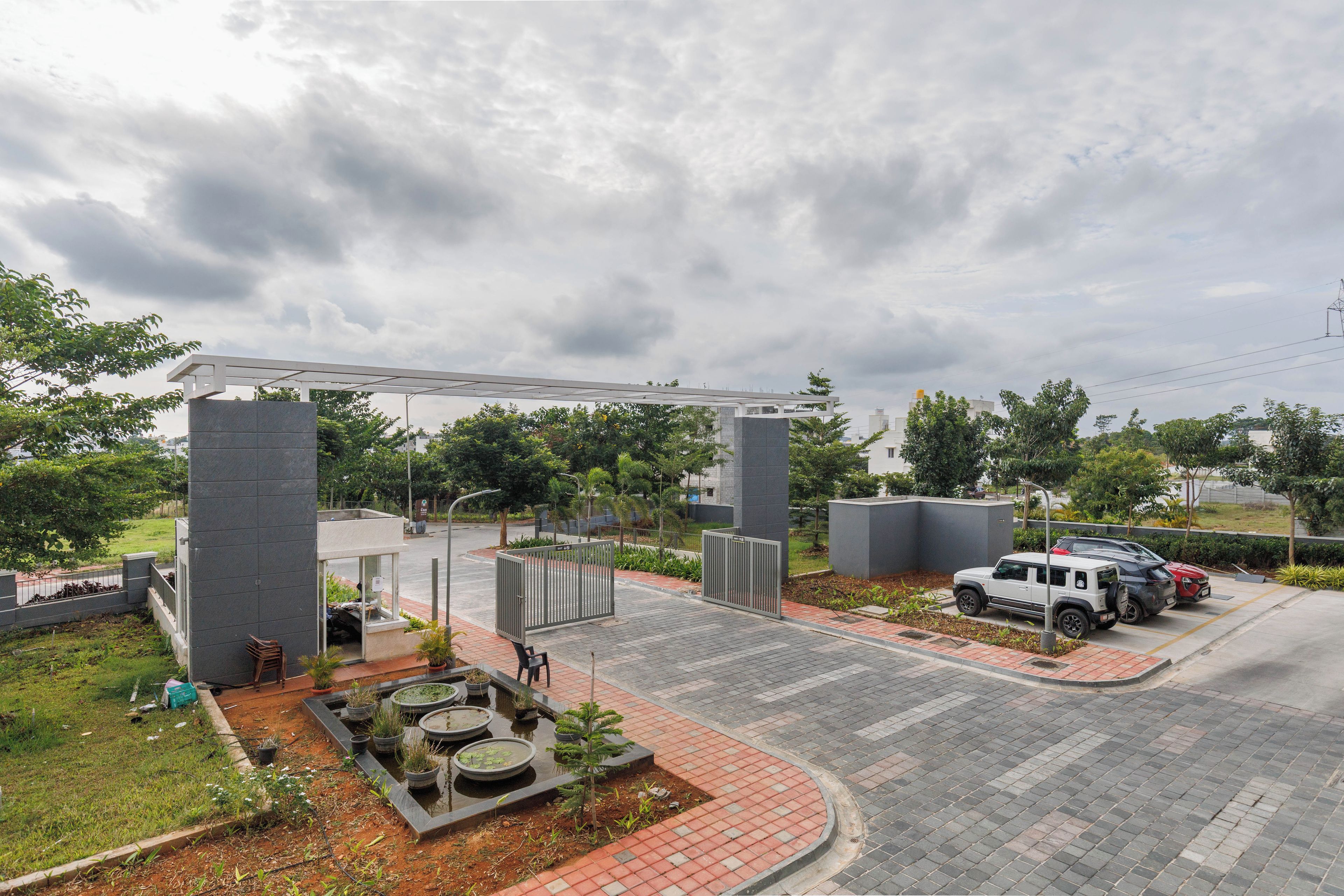 A parking area with a gated entrance, a small kiosk, and a paved walkway.