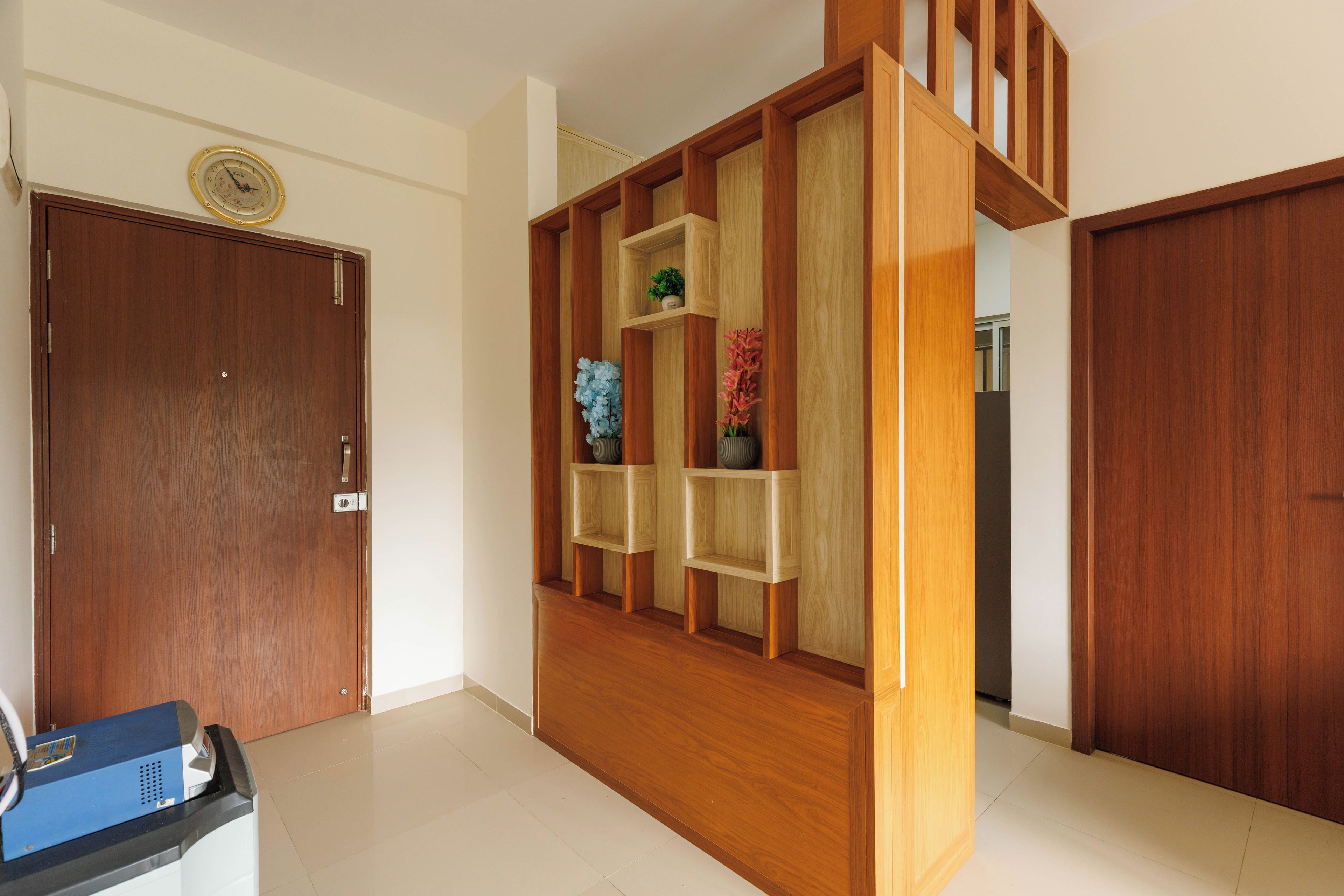 A room with a wooden door, a built-in wooden shelving unit with decorative items, and a tiled floor.