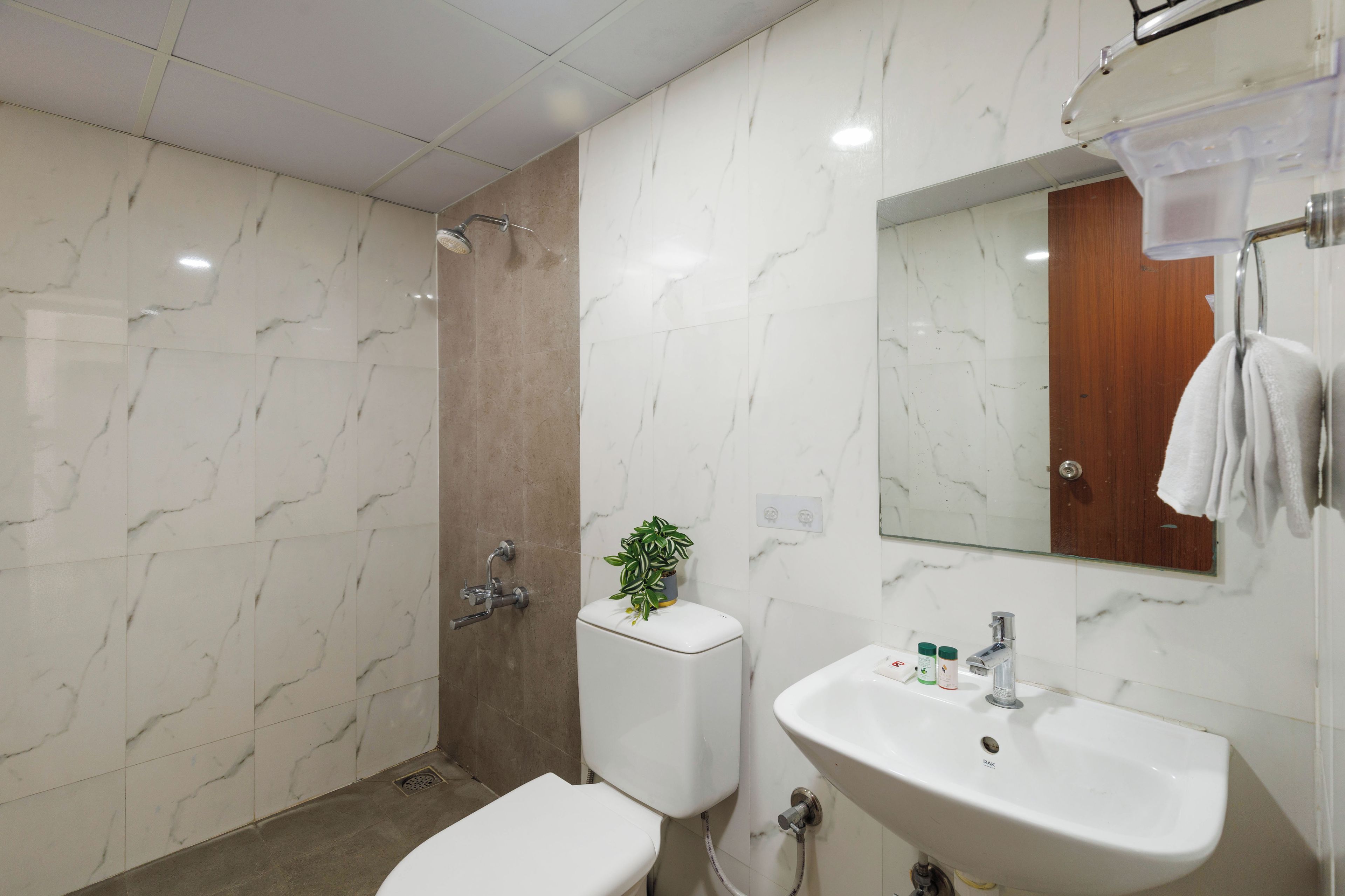 A bathroom with a toilet, sink, and shower.