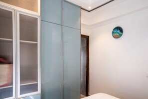 A bedroom with a wardrobe, a bed, and a wall clock. - Belmont by Redolive 3bhk 30min DLF Cyber City (Sohna)
