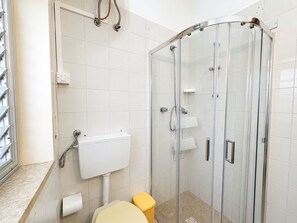 A modern bathroom with a glass shower enclosure, a white toilet, and a sink with a white basin. - Vacation Home in Marina Di Modica with 3 bedrooms sleeps 5 (Marina Di Modica)