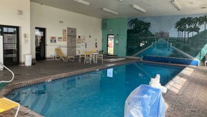 An indoor swimming pool with a mural of a tropical landscape, a covered area with chairs, and an exit sign. - 1 King Bed | Non-Smoking, Micfridge (Deming NM)