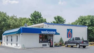 Ein kleines, eingeschossiges Gebäude mit einem blauen Dach und einem 'Welcome'-Schild.
