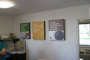 A room with a desk, a chair, and three posters on the wall.