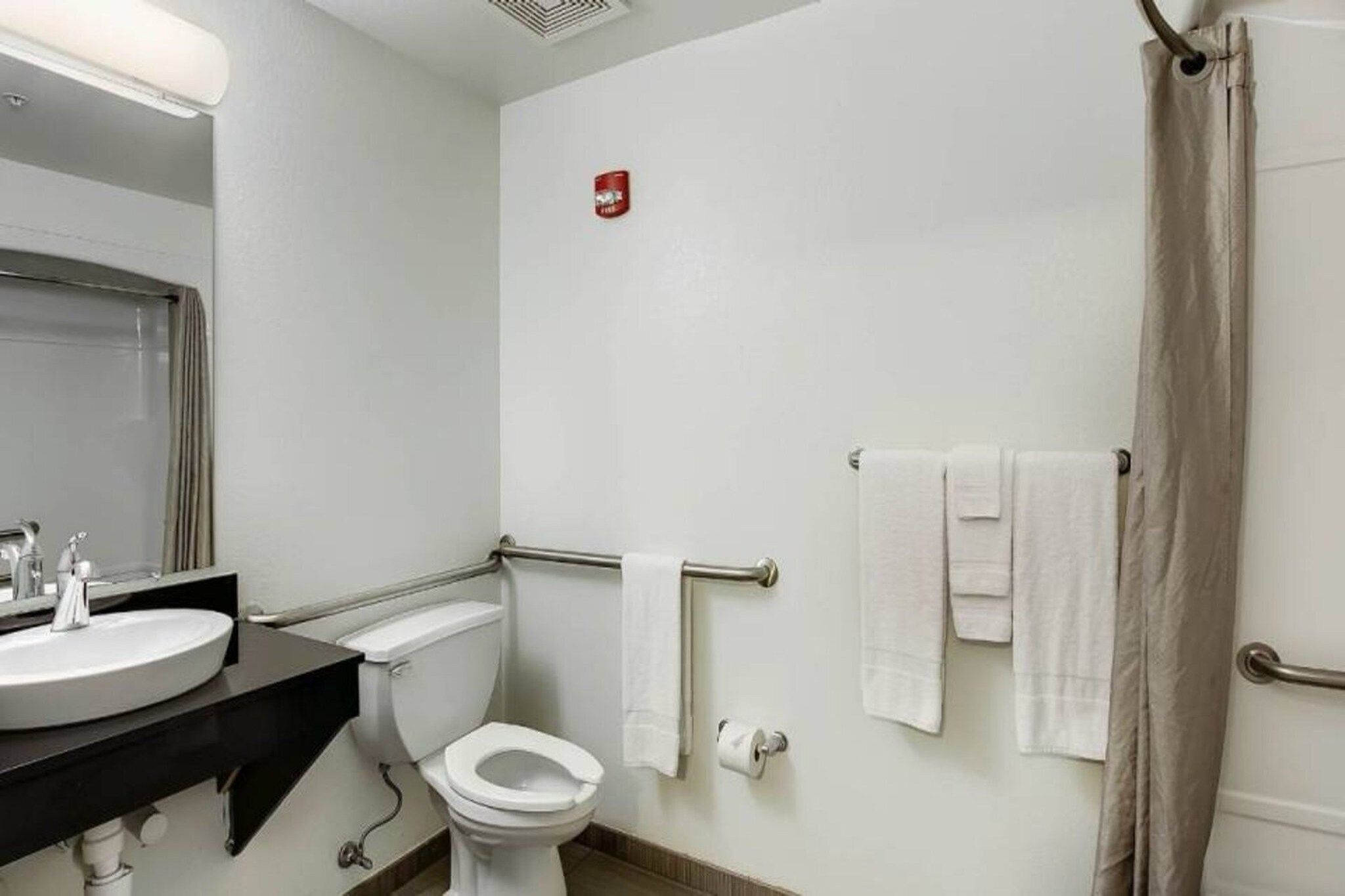 A bathroom with a toilet, sink, and shower area.