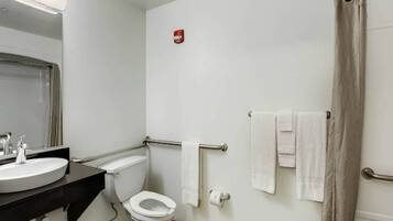 A bathroom with a toilet, sink, and shower area.