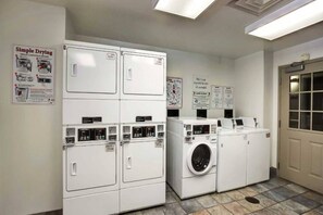 A laundry facility with stacked dryers and a front-loading washing machine. - 1 queen bed|Micfridge|Smoking (East Brunswick)