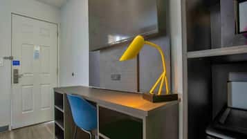A room with a desk, a chair, a lamp, and a door.