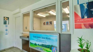 A reception desk with a digital screen displaying a message about booking faster and saving more. - 1 Full Bed | ADA | Tub (Richland)