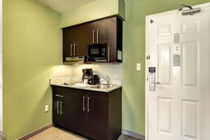 A compact kitchen with dark cabinets, a microwave, and a coffee maker. - 2 full beds | Non-smoking (East Brunswick)