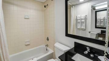 Un baño con bañera, inodoro, lavabo y espejo.