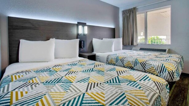 A hotel room with two beds, a large window, and a modern design. - 2 Full Beds | Micfridge (Richland)