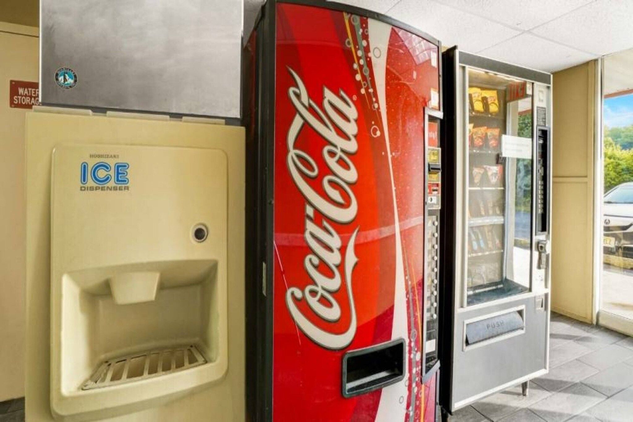 Una macchina automatica di Coca-Cola e un distributore di ghiaccio in un contesto alberghiero.