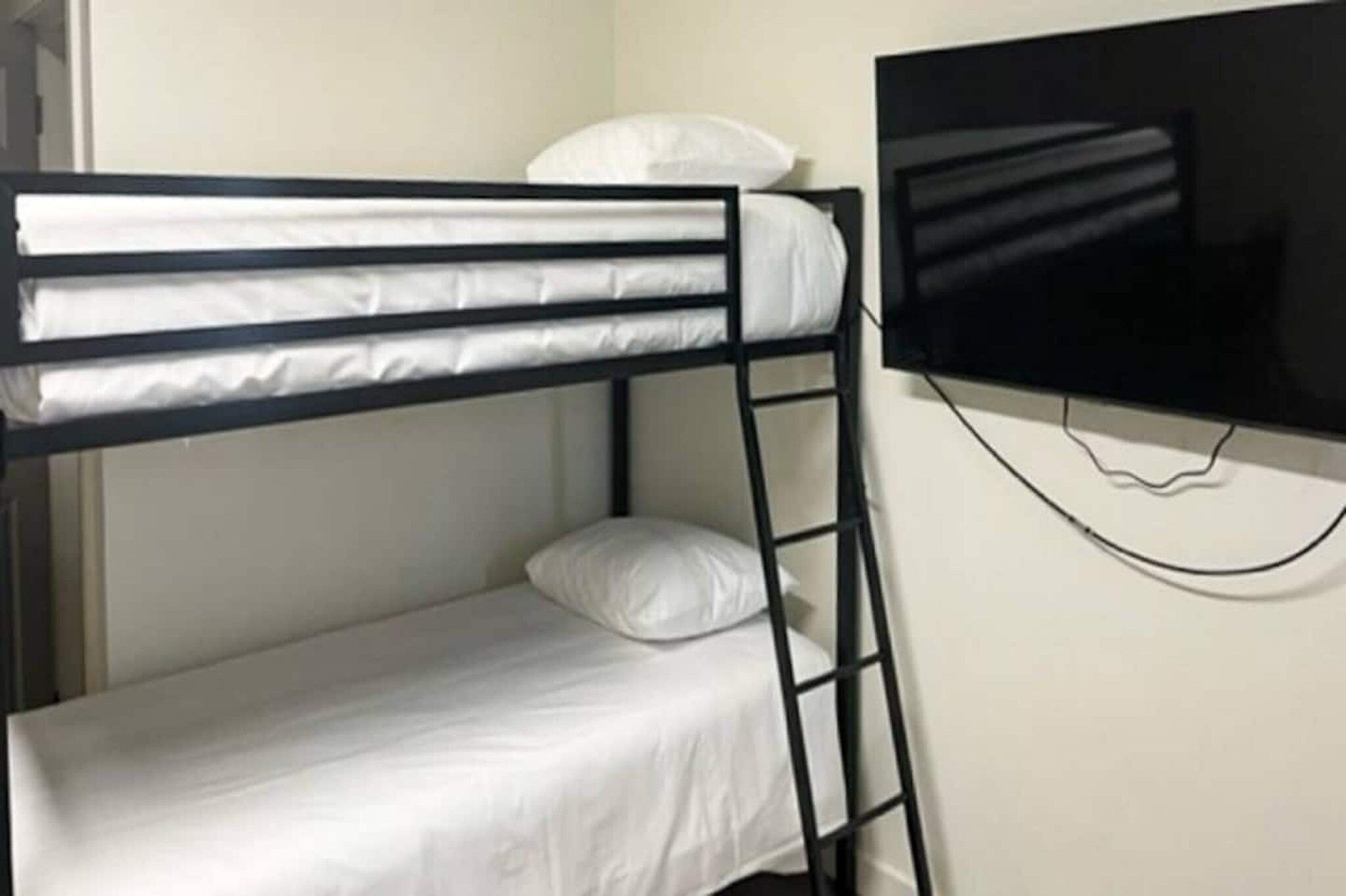 Ein Etagenbett mit einem an der Wand darüber angebrachten Fernseher.