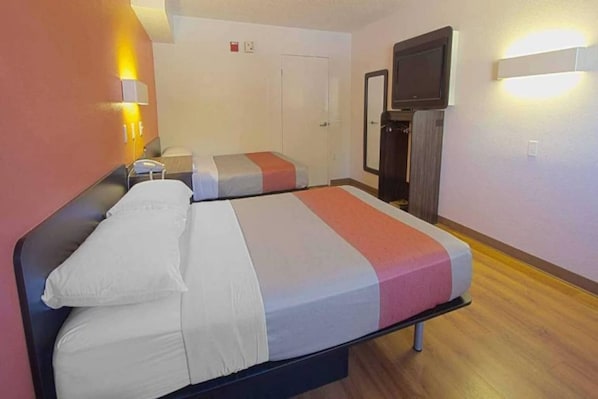 Ein Hotelzimmer mit einem Bett, einem Fernseher und einem kleinen Schreibtisch.