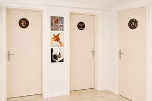 A hallway with three doors, each featuring a circular welcome sign with a fox design. - A cozy, well-furnished half-timbered house near Winterberg Hildfeld. (Hildfeld)