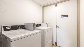 Un cuarto de lavado con lavadora y secadora Maytag, un lavamanos blanco y una puerta con la leyenda 'Cuarto de Lavado'.