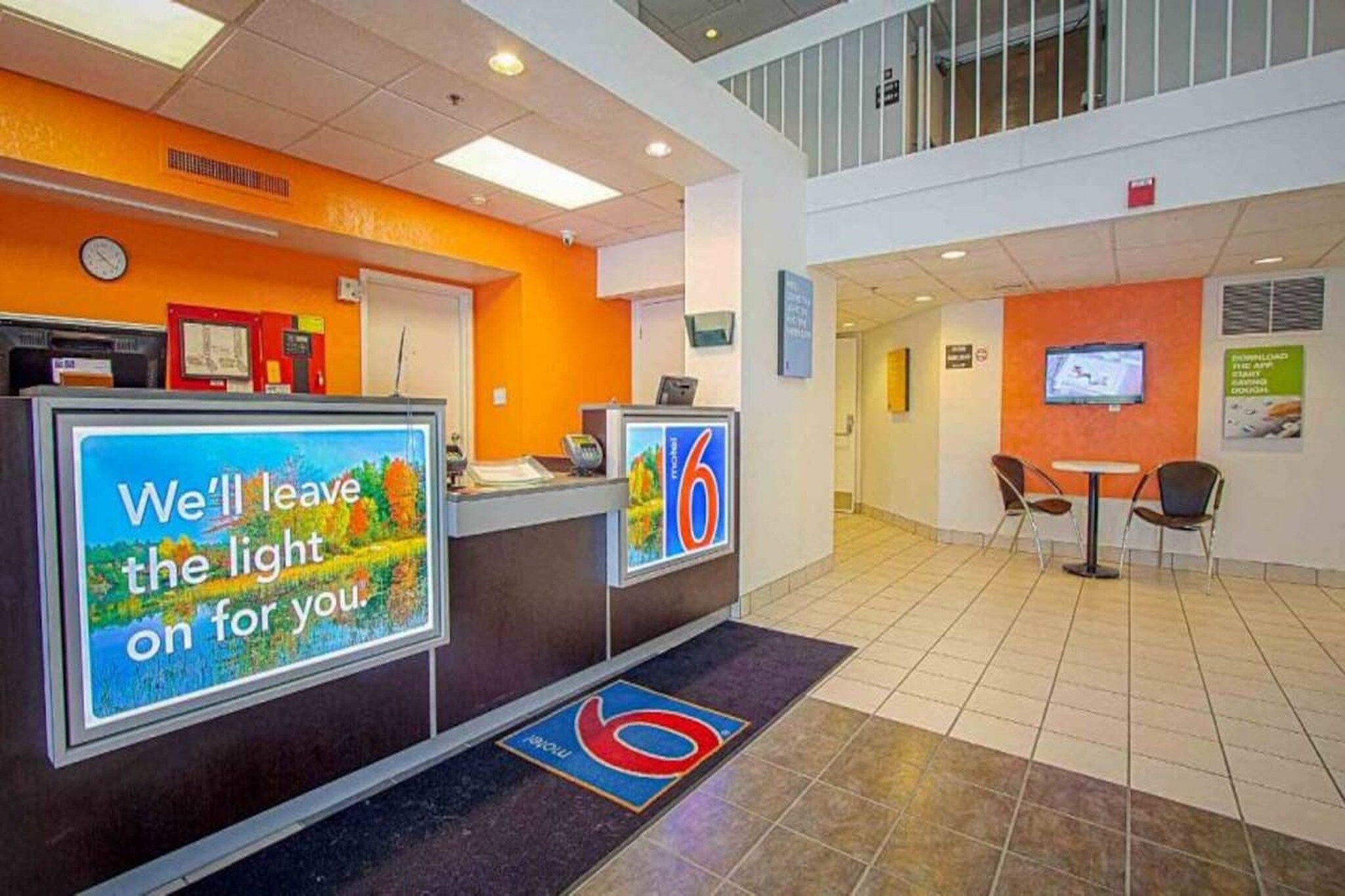 Un'area reception di un hotel con un display digitale, un orologio e una targa che indica il numero dell'hotel.