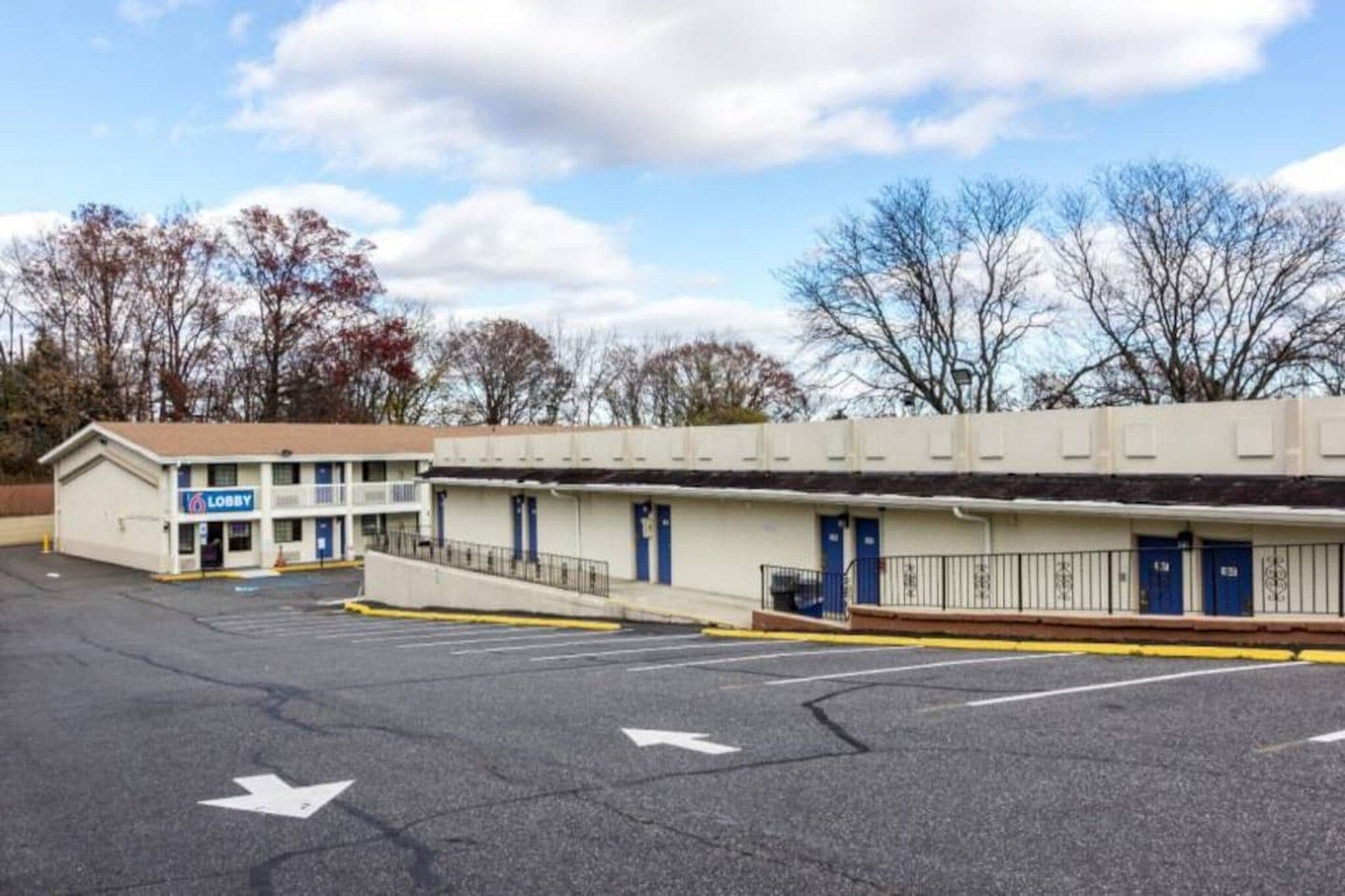 A motel with a lobby, multiple rooms, and a parking lot.
