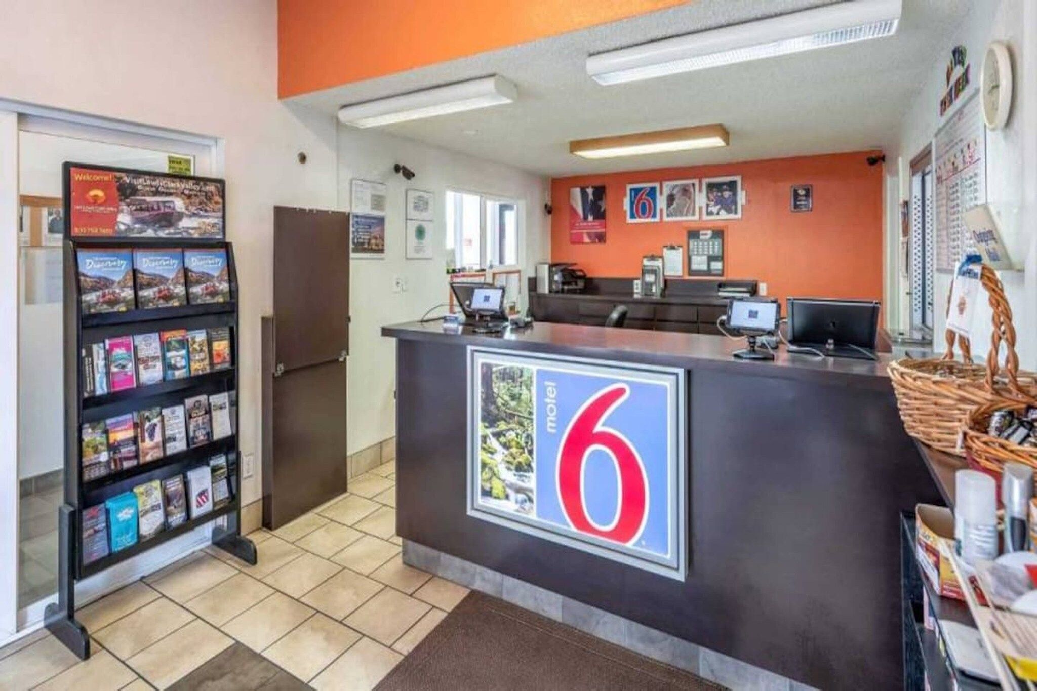 A reception desk with a large number '6' sign, a computer, and a counter with various items.
