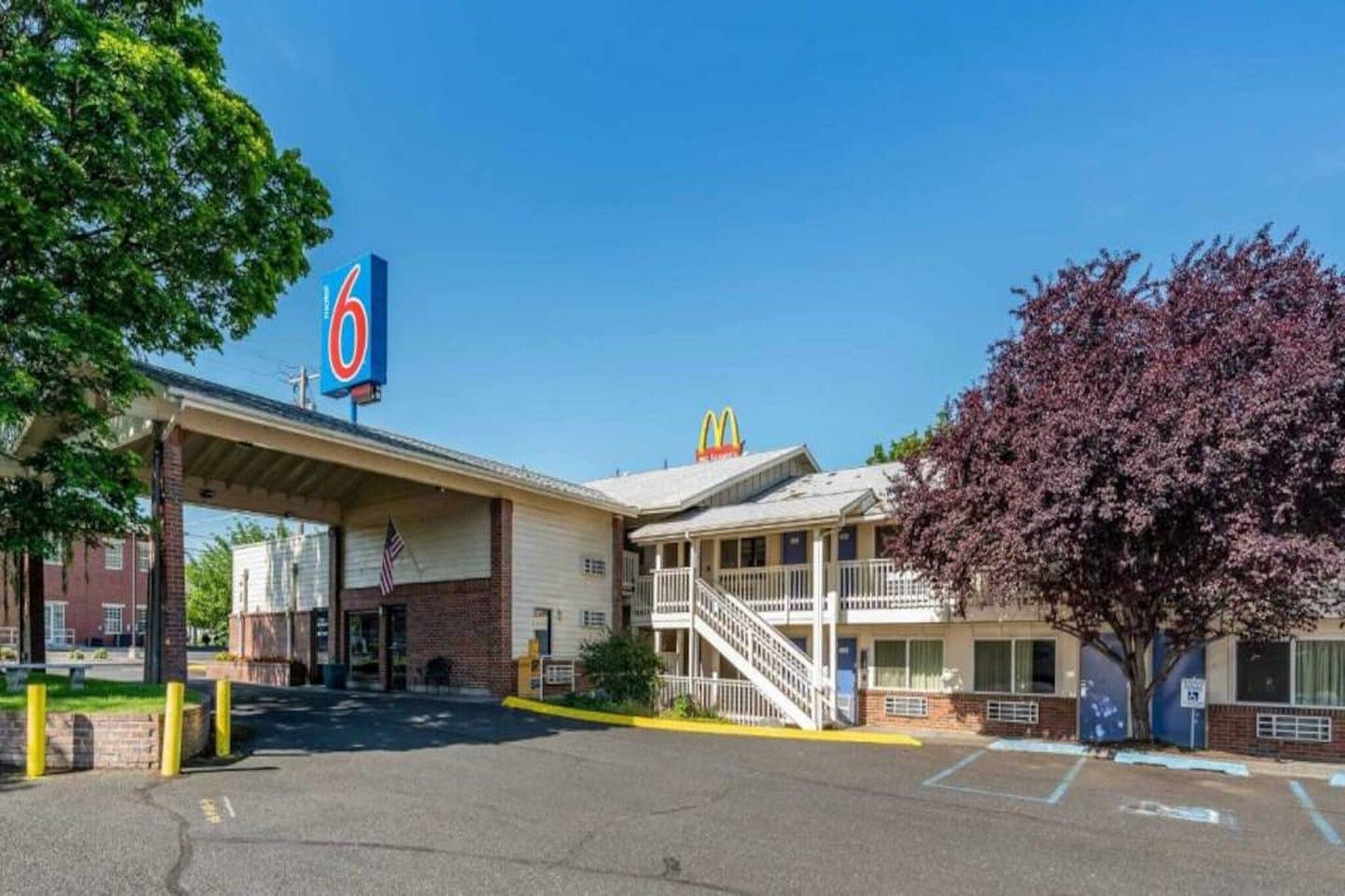 Et motel med en McDonald's-logo, et overdækket parkeringsområde og en toetages bygning med balkon.