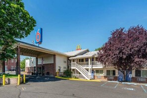 A motel with a McDonald's logo, a covered parking area, and a two-story building with a balcony.