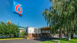 Un motel con un gran letrero azul, el logotipo de McDonald's y un estacionamiento.