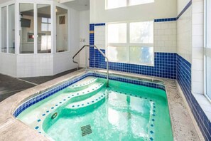 A swimming pool with a blue tiled border, a metal ladder, and a window above the pool. - 2 Queen Beds | Non-Smoking (Clarkston)